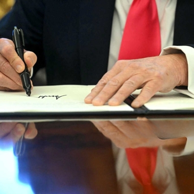 President Trump's hands shown signing an executive order