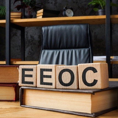 Empty office chair with "EEOC" written on wooden blocks.