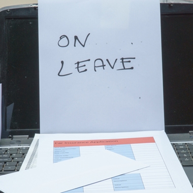 Laptop with note saying "On Leave"