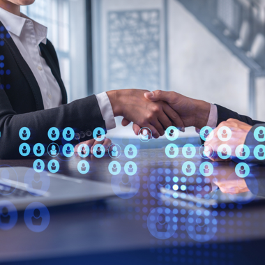 Two people shaking hands, surrounded by people icons in different colors