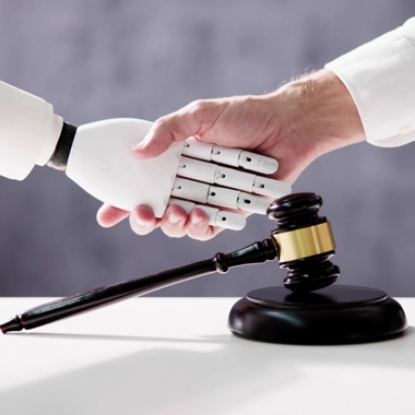 A person shaking hands with a robot in front of a gavel