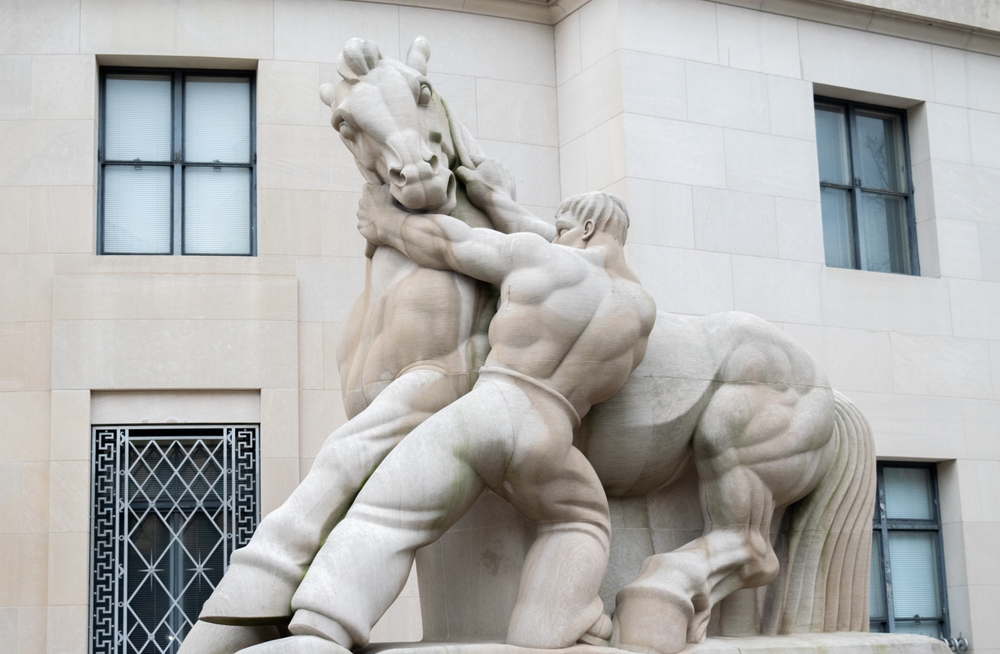 Statue of man holding horse