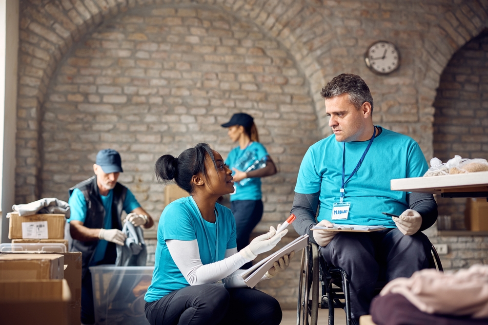 Woman crouching to speak with a man in a wheelchair